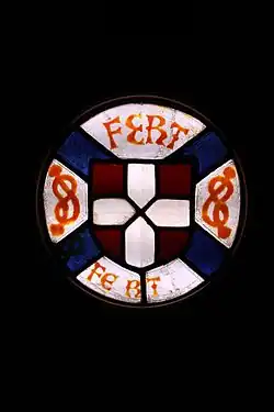 Vitrail représentant les symboles de la maison de Savoie, le blason de rouge à la croix d'argent, ainsi que des nœuds ou lacs d'Amour et le devise FERT.