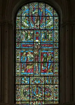 Vitrail gothique à dominante bleue centré sur une crucifixion.