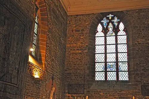 Dans la grande fenêtre ogivale les armoiries du baron de Launoit avec, dans la partie supérieure, un motif religieux représentant la Sainte Trinité. Dans la fenêtre à gauche de l'autel, les armoiries de la comtesse de Limburg Stirum et celle du baron Snoy.