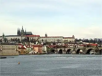Photographie en couleurs du Hradčany de Prague avec la Vltava qui coule au premier plan