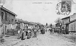 Vomécourt carte postale ancienne (septembre 1912 ?).  Vue de la rue principale depuis le parvis de l'église en direction d'Epinal (vers le sud-ouest).