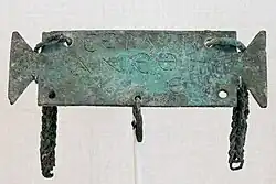 Petite tabula ansata portant une inscription votive en grec à Sérapis. Objet romain de la période impériale.