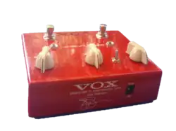 pédale d'effet rouge avec trois boutons blancs et la signature de Joe Satriani sur le côté