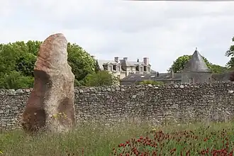 Menhir-polissoir de la Grouas devant le château des Noyers.