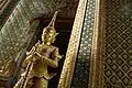 Deux yakshas dorés gardent l'une des quatre entrées du Phra Mondop, la bibliothèque. À leurs pieds, deux nâgas à cinq têtes.