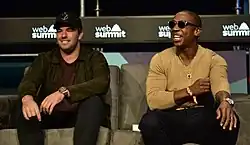 Deux hommes souriants assis.