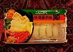 Un emballage de nouilles rigide, contenant des nouilles japonaises baignant dans un liquide clair.