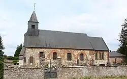 Église de Wiège, derrière laquelle se dressent en contrebas les arbres du parc du château.