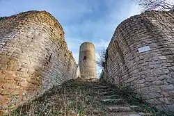 photographie montrant une grosse tour cylindrique à l’arrière plan, au bout d’un couloir entre deux murs