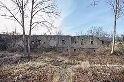 photographie montrant un mur ruiné avec des trous à l’emplacement des fenêtres