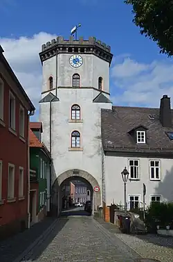Photographie d'une tour percée d'un porte de ville