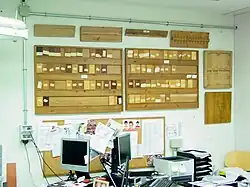 Photo d'un laboratoire avec des échantillons de bois alignés sur des panneaux au mur.