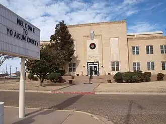 Vue du panneau d'accueil dans le comté et d'un bâtiment blanc.