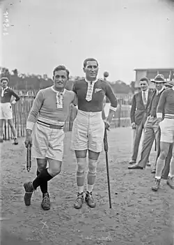 Photographie en noir et blanc de deux hommes debout prenant la pose côte à côte.